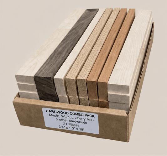 A cardboard box containing a hardwood combo pack with multiple rectangular wood strips in different natural tones, including light beige, medium brown, and dark charcoal. A white label on the front reads 'HARDWOOD COMBO PACK - Maple, Walnut, Cherry Mix - 21 Pieces 3/4" x 1.